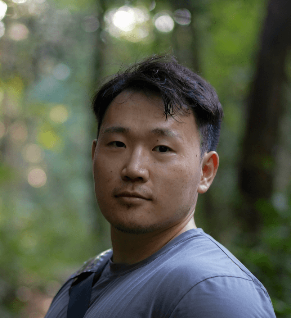 a man with a backpack standing in the woods